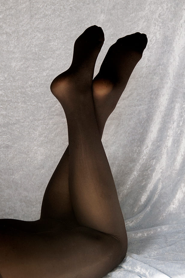 Des jambes de femme portent un collant noir fabriqué à partir de graines de ricin.